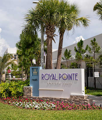 A sign for Royal Pointe Apartment Homes is in front of a building.