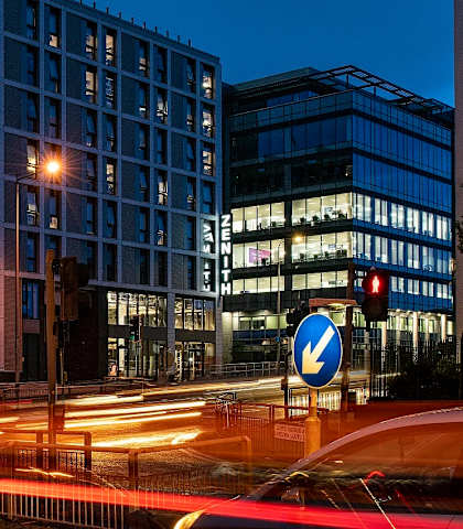 a city street at night with traffic lights and buildings
