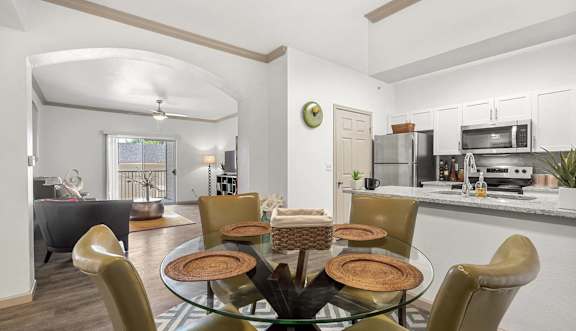 A modern dining room with a glass table and chairs.