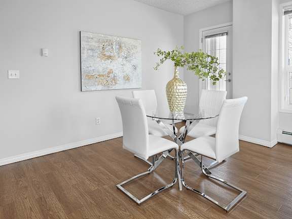 a dining room with a glass table and white chairs