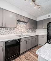 a kitchen with white counter tops and black appliances