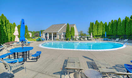 A large outdoor pool area with a building in the background.