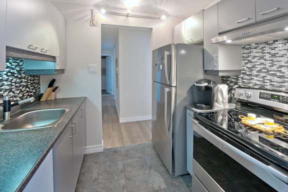 A kitchen with a stainless steel refrigerator and a sink.