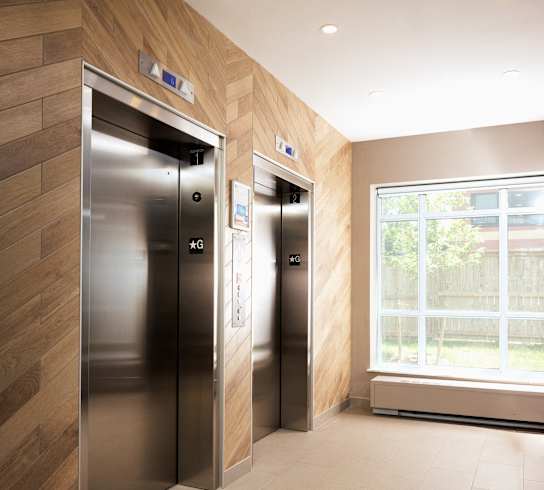 a lobby with two elevators and a window
