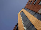 Thumbnail 8 of 8 - the corner of a brick building against a blue sky