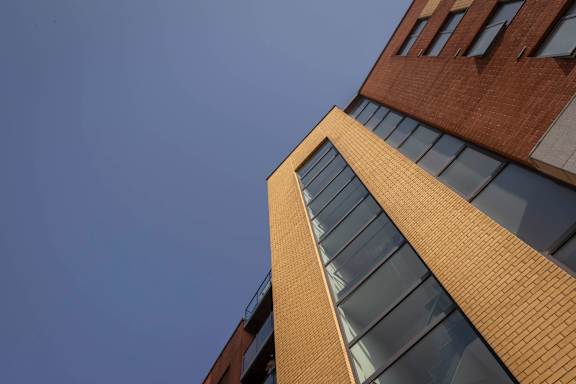 the corner of a brick building against a blue sky