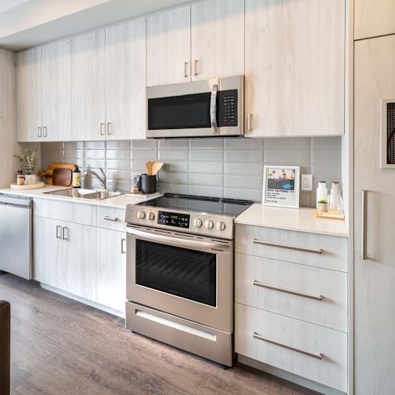 A modern kitchen with stainless steel appliances and wooden cabinets.