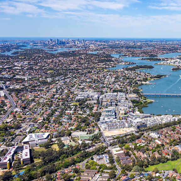 A cityscape with a large body of water and a bridge connecting two land masses.