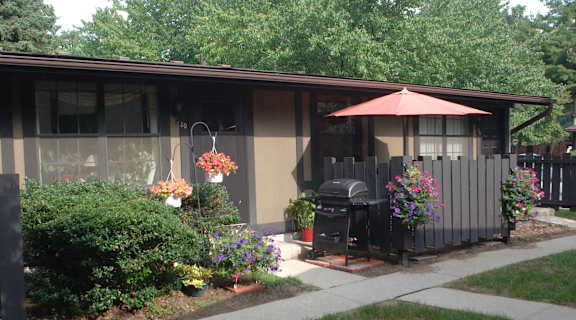 a patio in front of a house with a grill