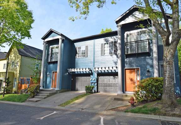 A blue two-story house with a balcony on the second floor.