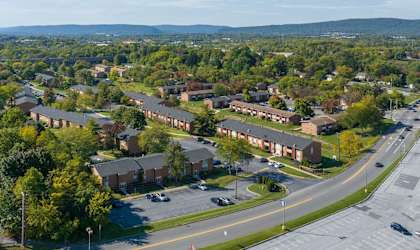 A road with cars and apartment buildings on the side.