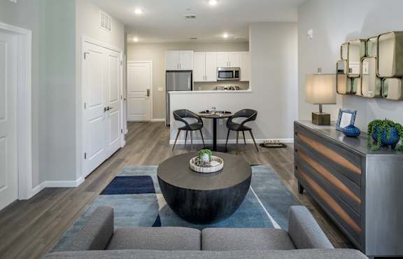 a living room with a couch and a coffee table in front of a kitchen at Eden & Main 55+ Apartments, Southington , Connecticut