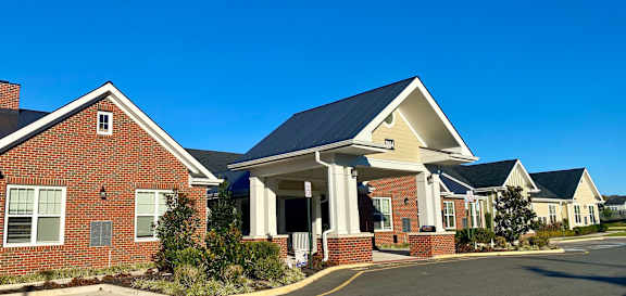 a brick house with a black roof and a street in front