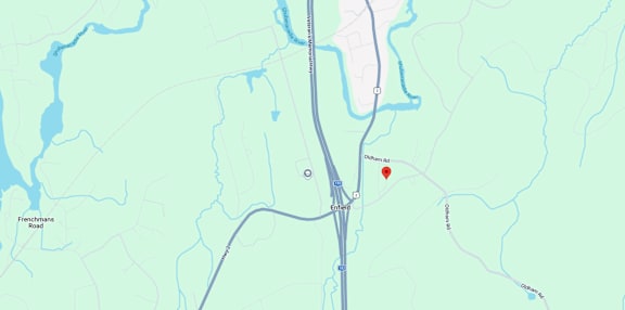 A map shows a red marker at the center of a parking lot, with various other locations and roads labeled around it.