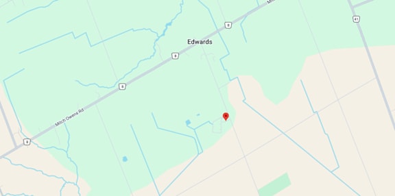 A map shows a red marker at the center of a parking lot, with various other locations and roads labeled around it.
