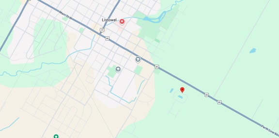 A map shows a red marker at the center of a parking lot, with various other locations and roads labeled around it.