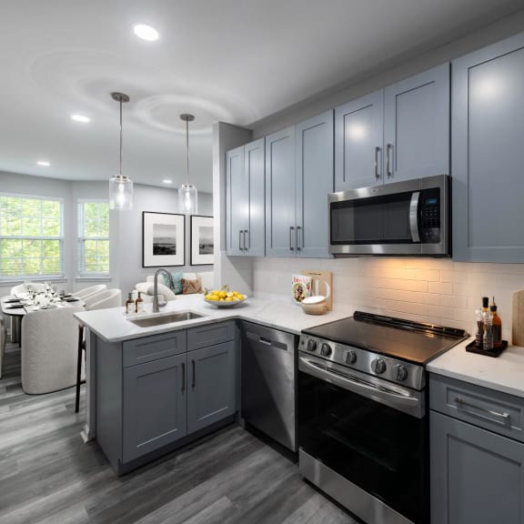 a kitchen with gray cabinets and a white counter top
