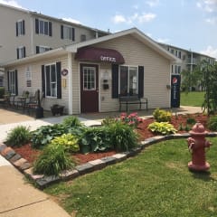 a fire hydrant in front of a building with a flower garden