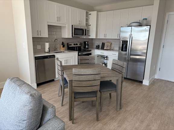 A kitchen with a table and chairs.