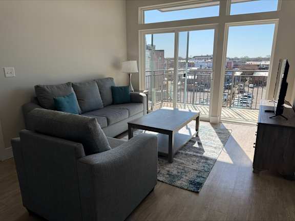 A living room with a grey couch and a coffee table.