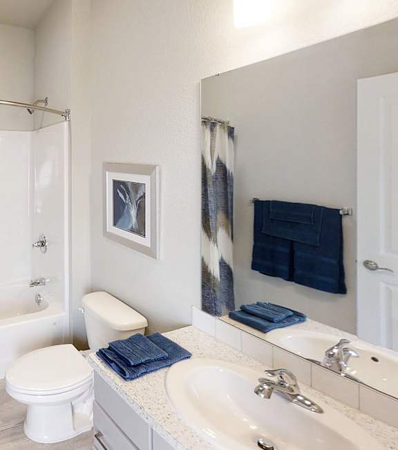 A bathroom with a toilet, sink, and shower curtain.