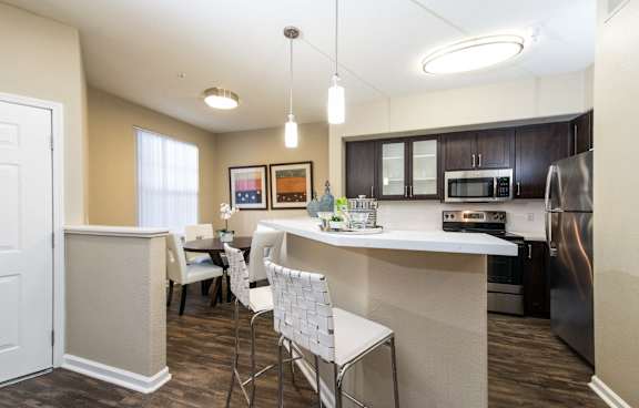 A modern kitchen with a white island and stainless steel appliances.