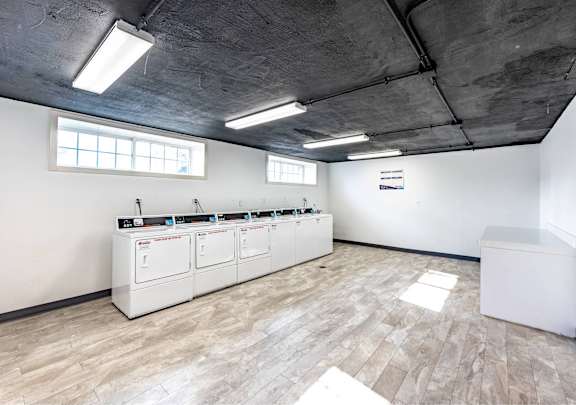 A room with a row of white machines on the wall.