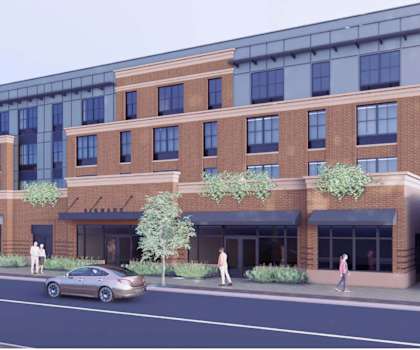 A modern building with a glass facade and a brick exterior is depicted in the image.
