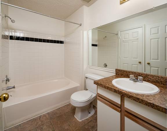 a bathroom with a sink toilet and tub and a mirror