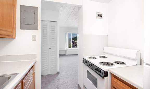 A kitchen with a white stove top oven and a white counter top at Bridgeville Towers, Bridgeville, 15017