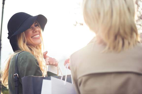 Two women are shopping and carrying bags.