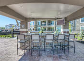 Thumbnail 8 of 53 - apartment grilling station with two grills and a seating area  at Waterside Residences on Quivira, Lenexa, KS, 66215