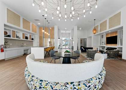 A modern kitchen with a white island and a dining table with chairs.