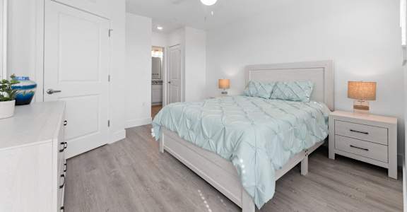 A bedroom with a bed, nightstand, and a ceiling fan.