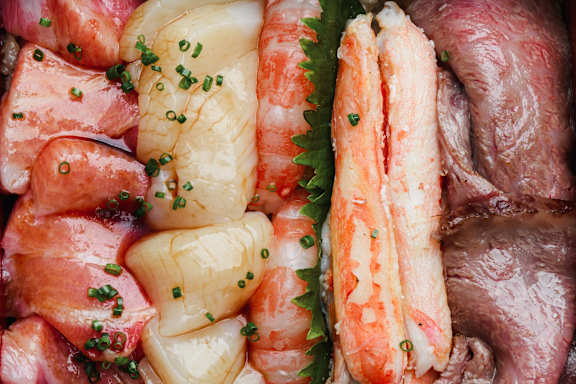 A variety of seafood including shrimp, scallops, and fish.