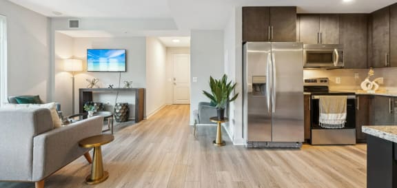 a kitchen and living room with a stainless steel refrigerator