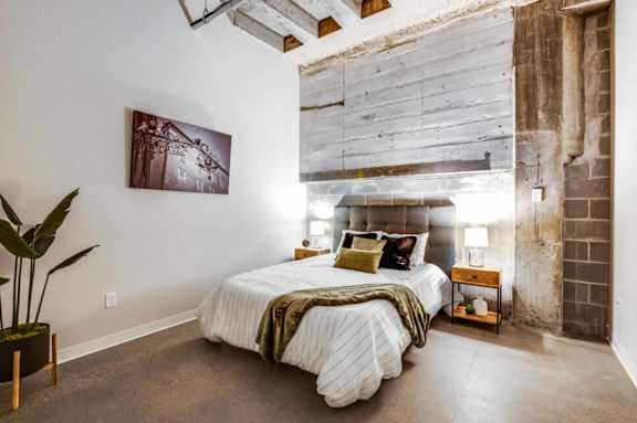 a bedroom with a bed and a exposed brick wall