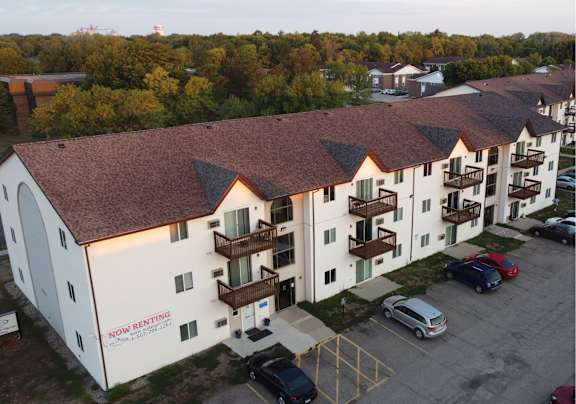 An apartment building with the words “Now Renting” on the side