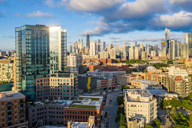 A cityscape with a mix of modern and older buildings under a partly cloudy sky.