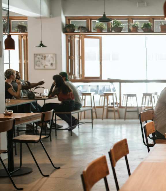 A group of people are sitting at tables in a restaurant.