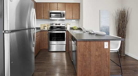 A modern kitchen with wooden cabinets and stainless steel appliances.