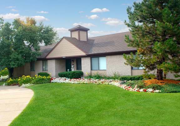 A house with a brown roof and a garden in front.