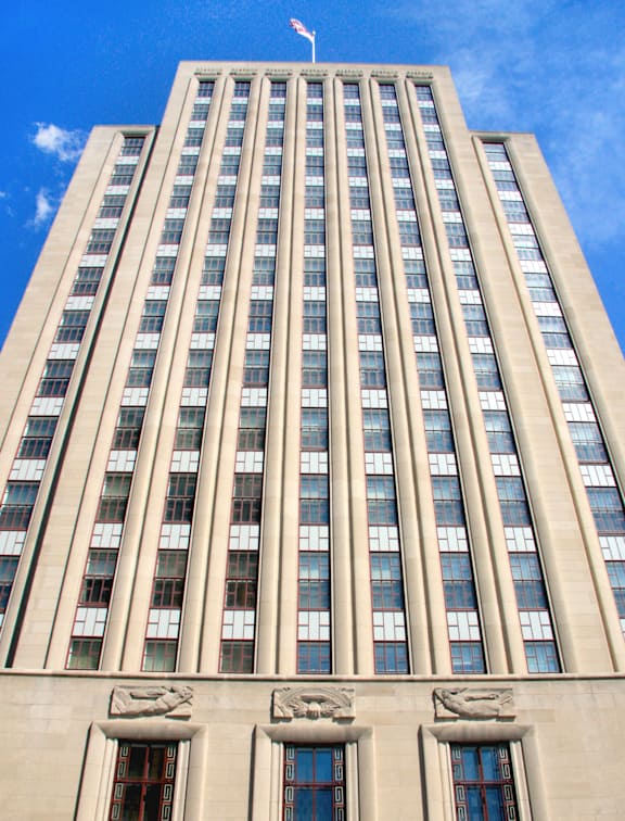 A tall building with a flag on top and a clear blue sky.