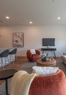 a living room with couches and chairs and a kitchen with a tv