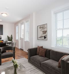 a living room with a couch and a table and a kitchen
