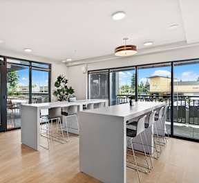 A modern dining room with a long table and chairs.