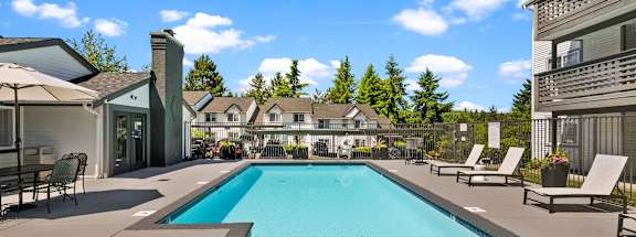 A large swimming pool with a slide and sun loungers.