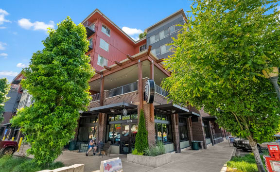 a building with a sidewalk and trees in front of it
