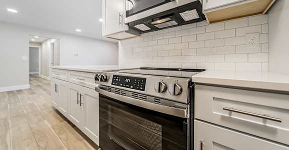 A modern kitchen with a stainless steel oven and microwave.