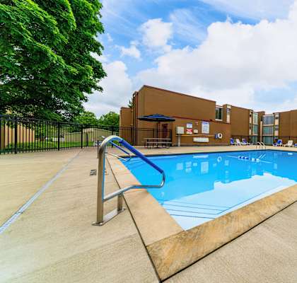 A large outdoor swimming pool with a diving board.